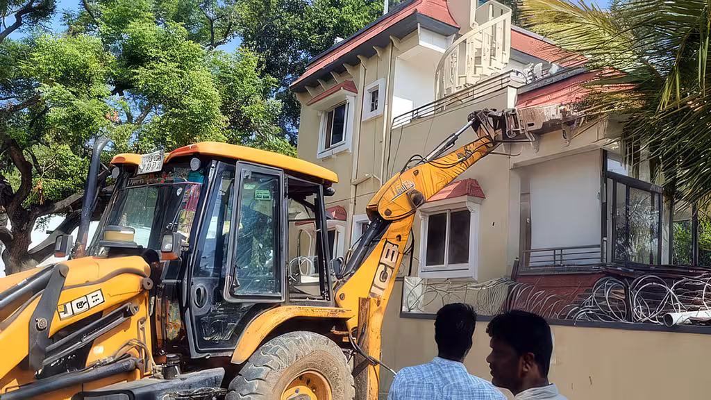 Excavator demolishing an alleged illegal school building on the Musi floodplain in Narsingi, Hyderabad.